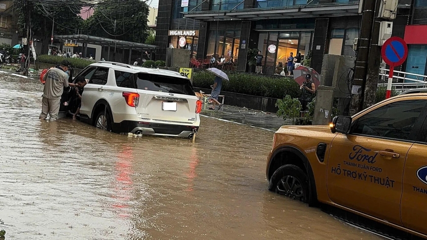 Xe ô tô chạy chậm qua đoạn đường ngập nước